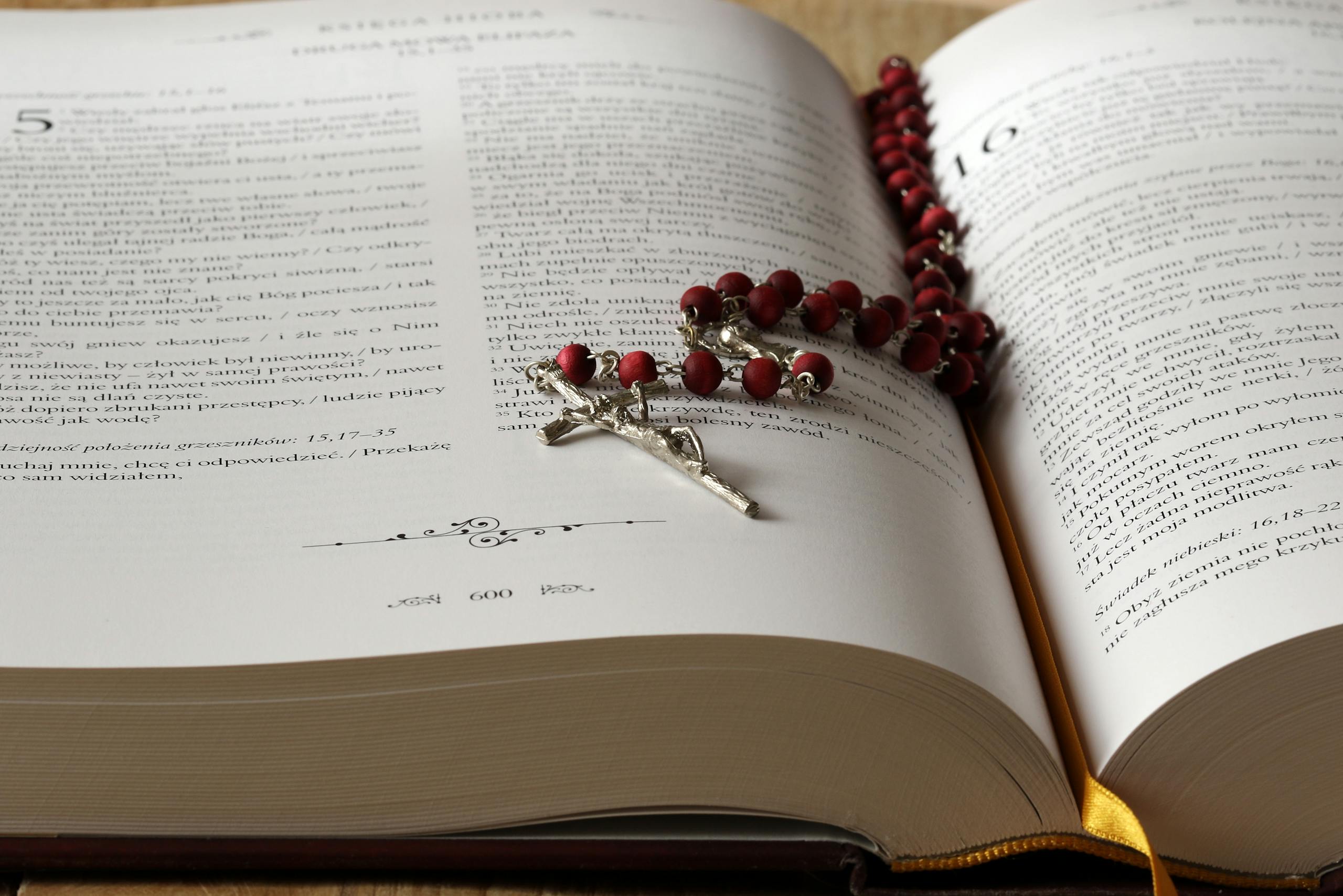 An open Bible with prayer beads