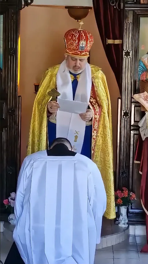 Ashley kneeling during his priestly ordination
